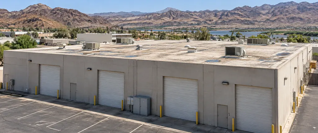 Warehouse with roll-up doors and a flat roof carrying rooftop units